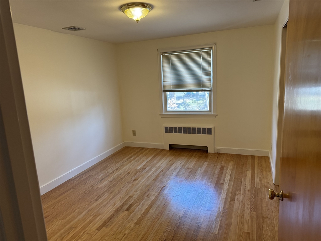 174 Forest Street Waltham, MA 02452 - Photo 6 of 15 an empty room with wooden floor and windows