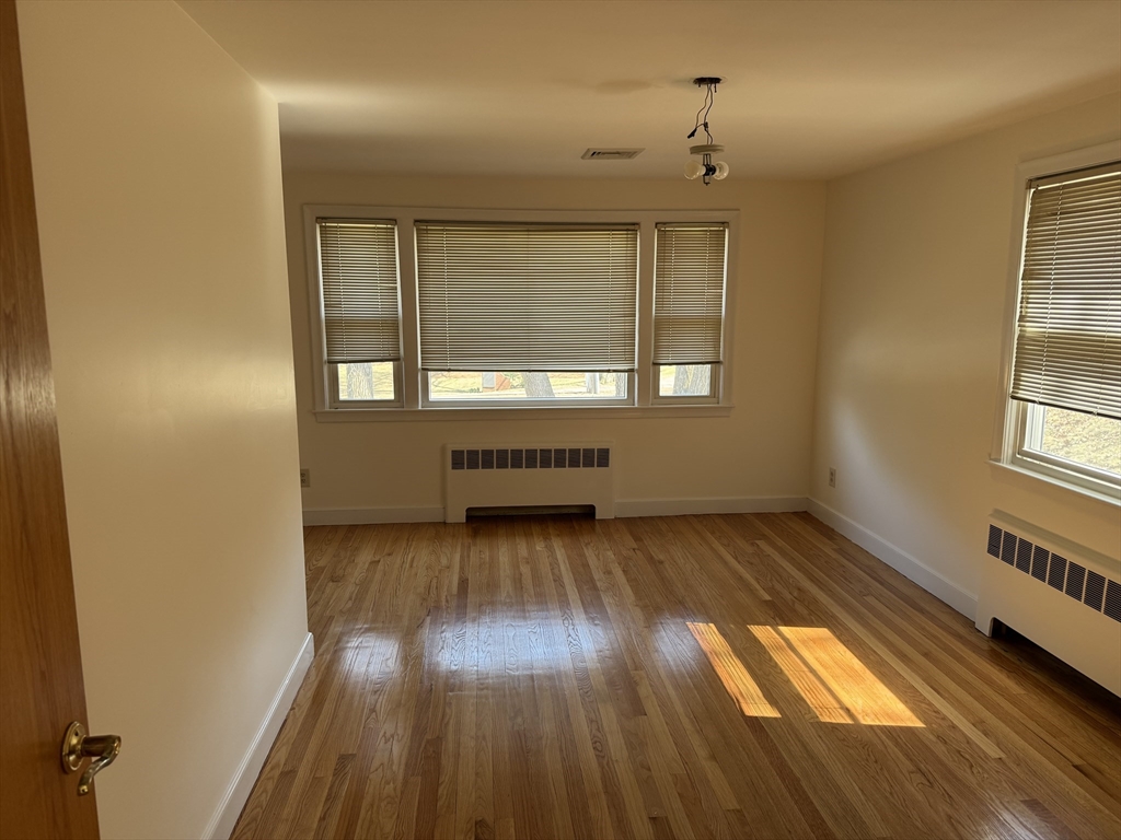 174 Forest Street Waltham, MA 02452 - Photo 9 of 15 an empty room with wooden floor and windows
