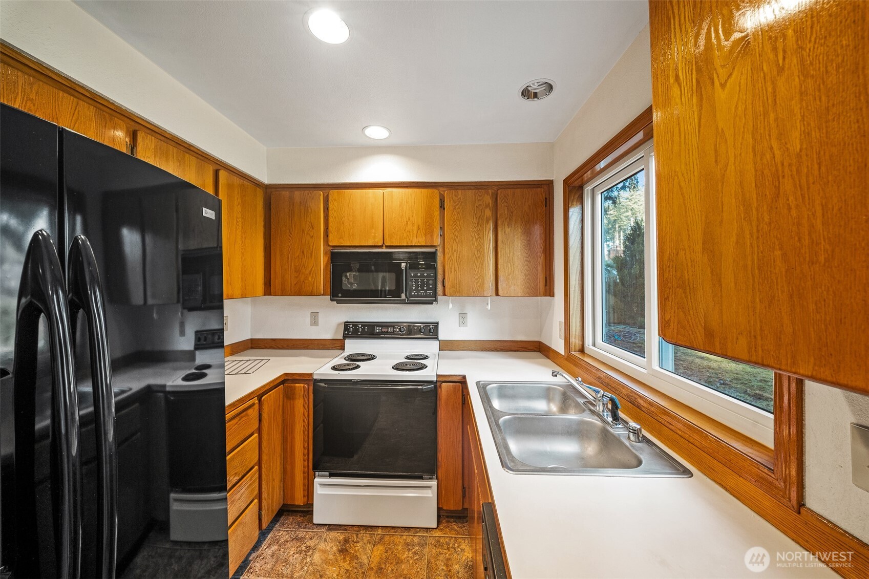 16011 Spanaway Loop Road South Spanaway, WA 98387 - Photo 9 of 35 a kitchen with stainless steel appliances a stove a sink and a refrigerator