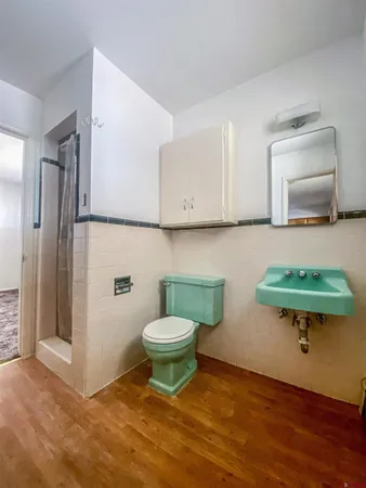 a bathroom with a toilet a sink and a mirror