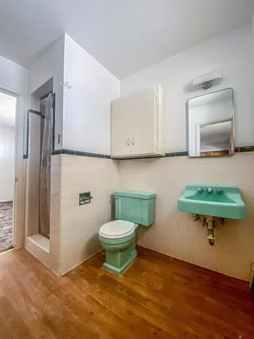 a bathroom with a toilet a sink and a mirror