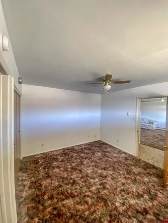 an empty room with kitchen space and wooden floor