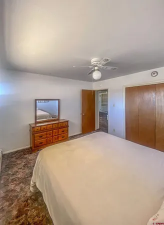 a bedroom with a bed and a painting on the wall
