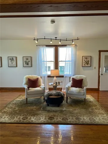 a large kitchen with kitchen island a stove a sink dishwasher and a refrigerator with wooden floor