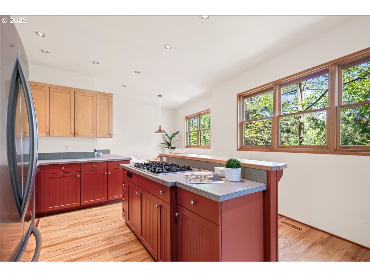 4908 Southwest Barnes Road Portland, OR 97221 - Photo 11 of 40 a kitchen with stainless steel appliances granite countertop a stove a sink dishwasher and a wooden cabinets