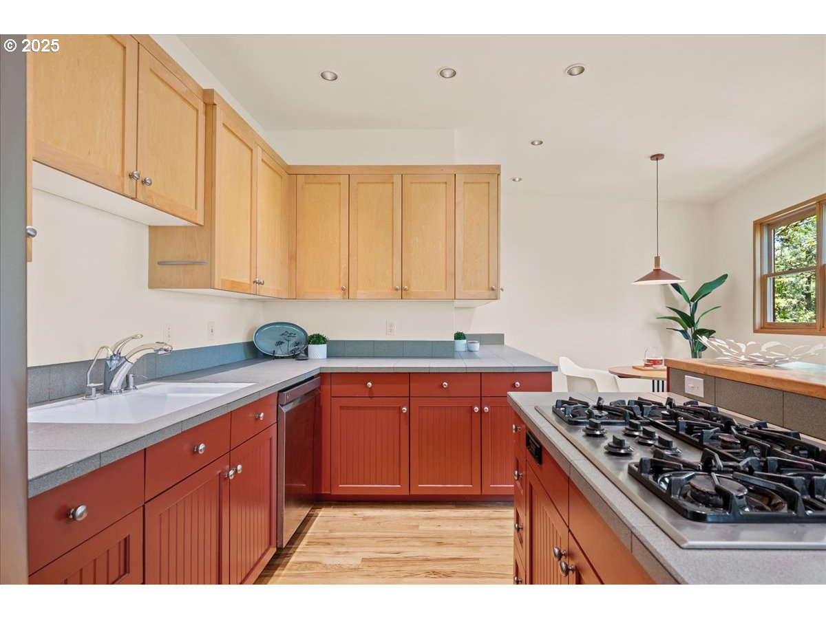 4908 Southwest Barnes Road Portland, OR 97221 - Photo 12 of 40 a kitchen with stainless steel appliances granite countertop a sink stove and cabinets