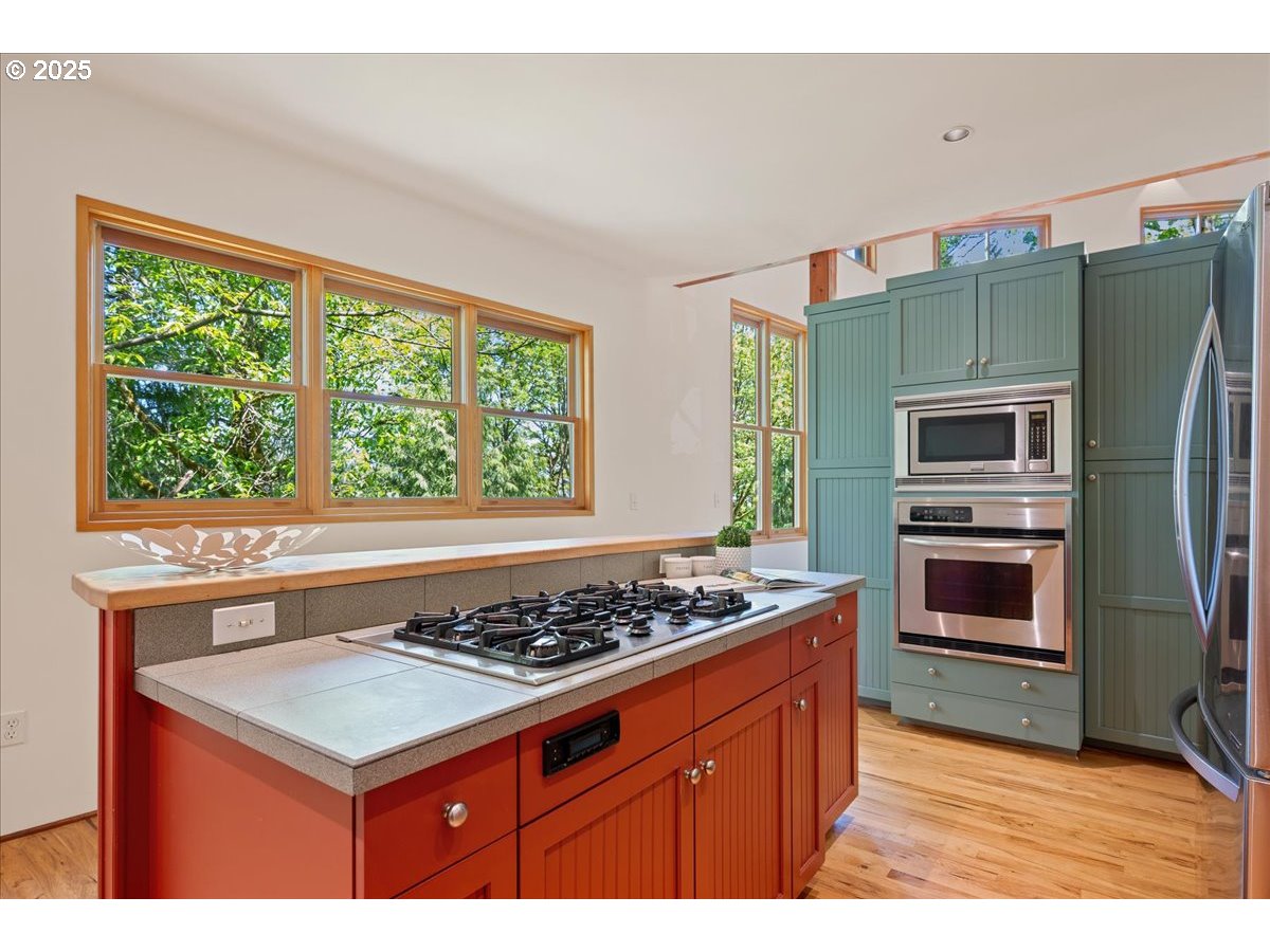 4908 Southwest Barnes Road Portland, OR 97221 - Photo 16 of 40 a kitchen with a stove a sink and a refrigerator