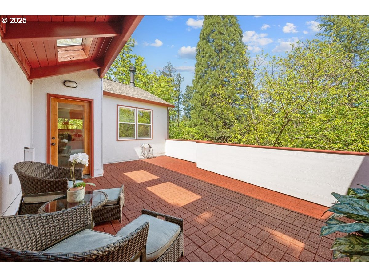 4908 Southwest Barnes Road Portland, OR 97221 - Photo 31 of 40 a view of a patio with two couches and table and chairs with potted plants