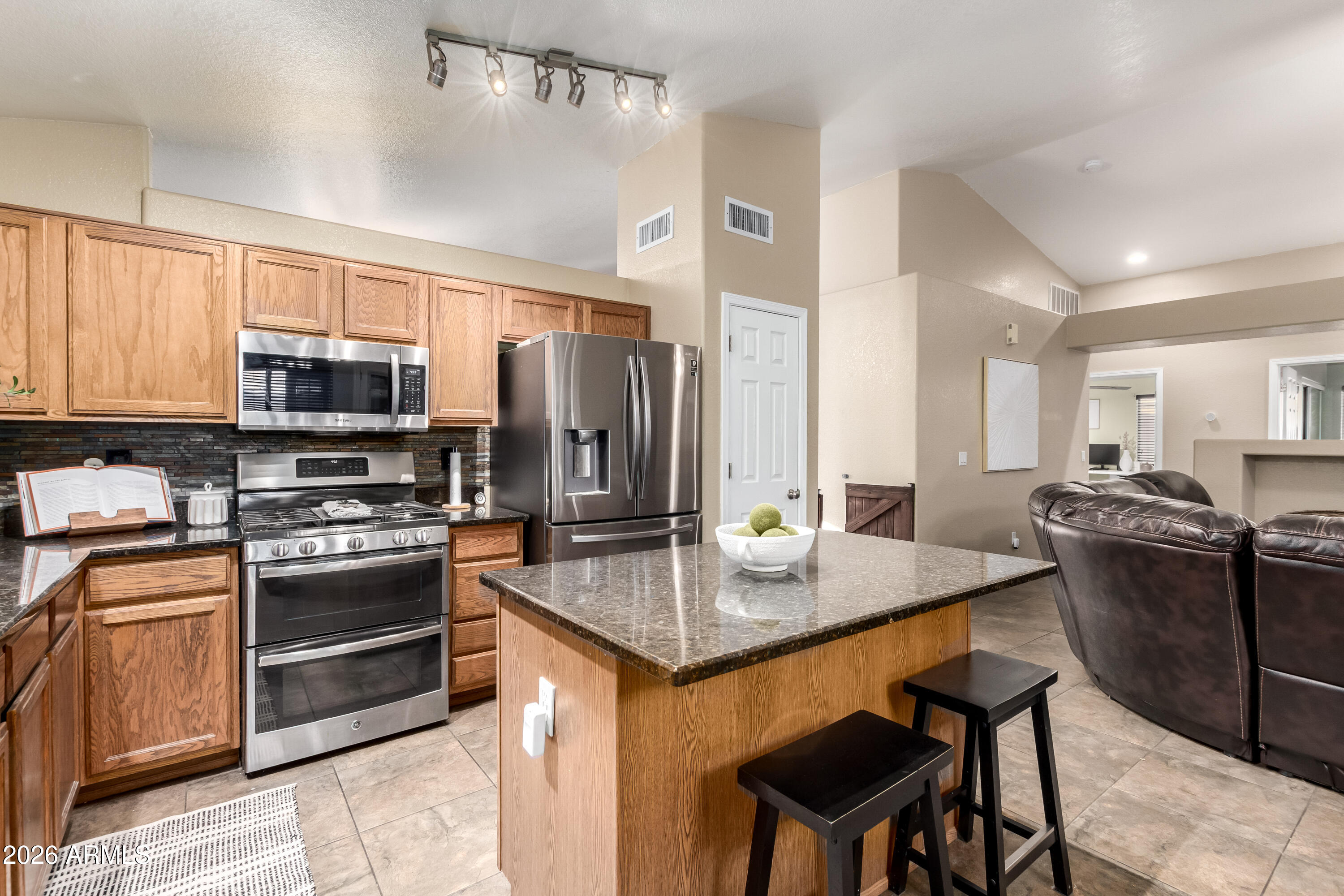 1147 North Marvin Street Gilbert, AZ 85233 - Photo 5 of 31 a kitchen with stainless steel appliances granite countertop a stove refrigerator and a microwave