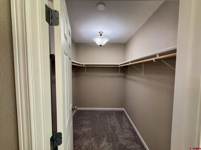 a view of staircase with lots of frames on wall and a window