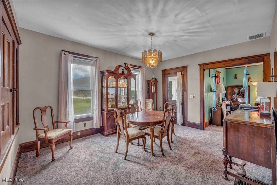 6873 Nichols Road Windham, OH 44288 - Photo 7 of 33 Dining space with a chandelier, light carpet, and baseboards