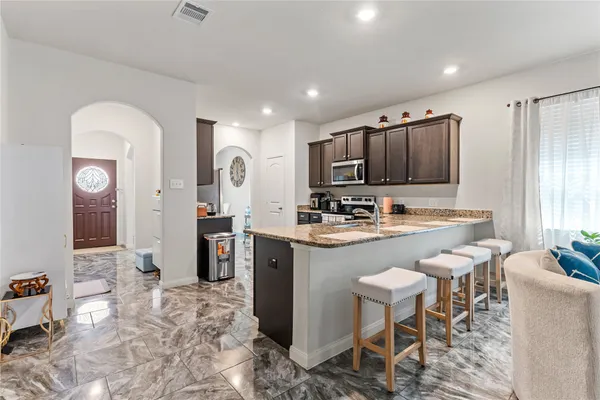a large kitchen with kitchen island granite countertop a sink and cabinets