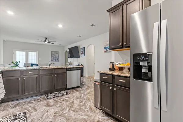 a kitchen with stainless steel appliances granite countertop a refrigerator and a stove top oven