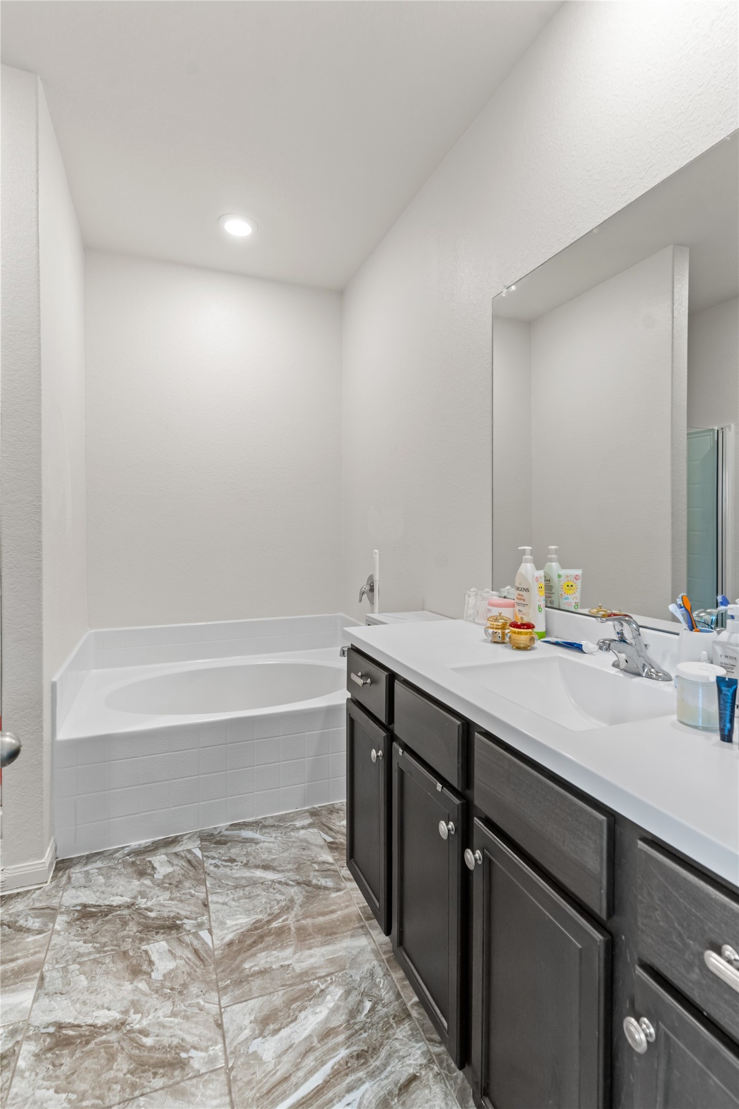 10731 Spring Brook Pass Drive Humble, TX 77396 - Photo 19 of 31 a bathroom with a tub sink and mirror
