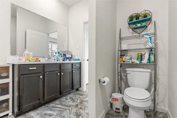 a bathroom with a toilet sink vanity and mirror