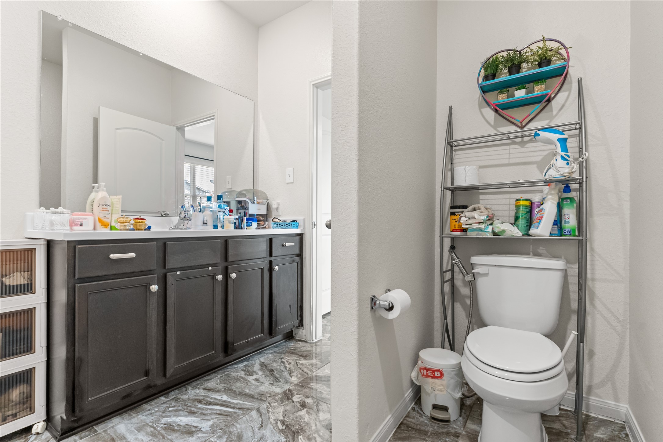 10731 Spring Brook Pass Drive Humble, TX 77396 - Photo 21 of 31 a bathroom with a toilet sink vanity and mirror