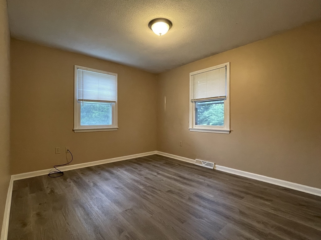 15 Carriage Lane Amherst, MA 01002 - Photo 14 of 23 a view of an empty room with wooden floor and a window