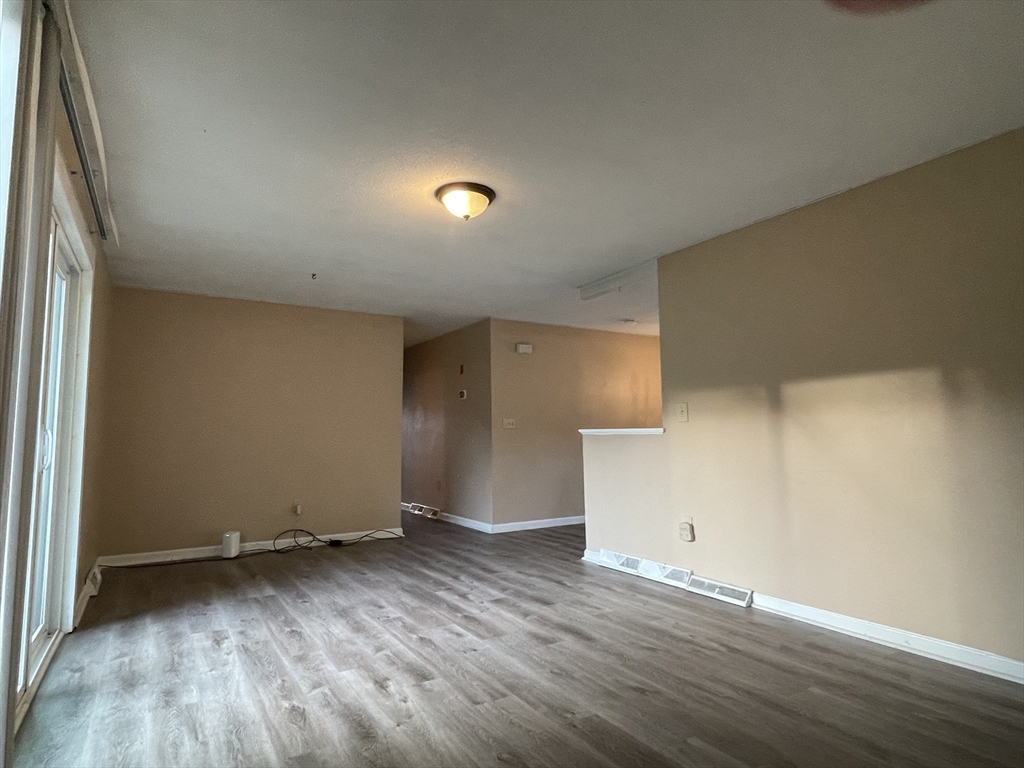 15 Carriage Lane Amherst, MA 01002 - Photo 8 of 23 an empty room with wooden floor and windows