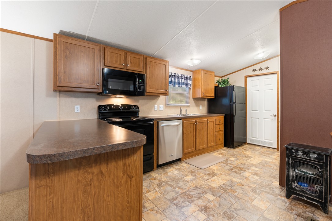 1061 Tafelski Road New Waverly, TX 77358 - Photo 12 of 37 a kitchen with stainless steel appliances granite countertop a refrigerator stove top oven a sink and dishwasher
