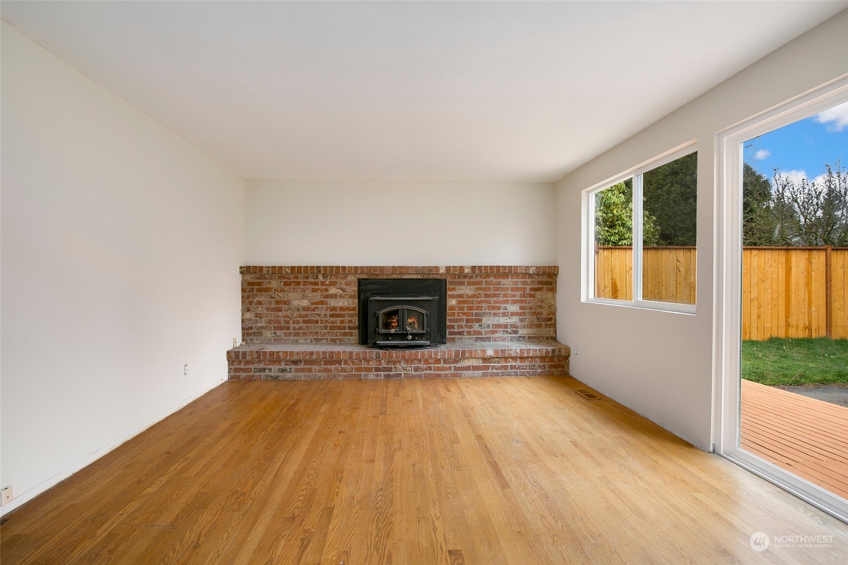 16810 143rd Avenue Southeast Renton, WA 98058 - Photo 11 of 38 a view of empty room with wooden floor and fireplace