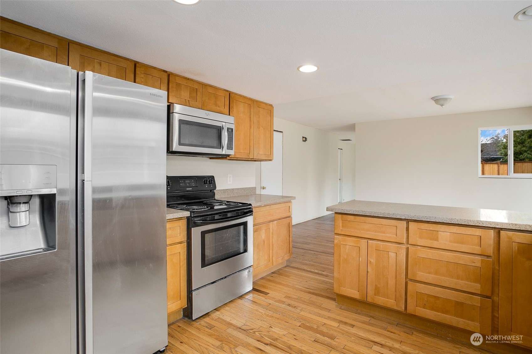 16810 143rd Avenue Southeast Renton, WA 98058 - Photo 16 of 38 a kitchen with granite countertop stainless steel appliances and wooden cabinets