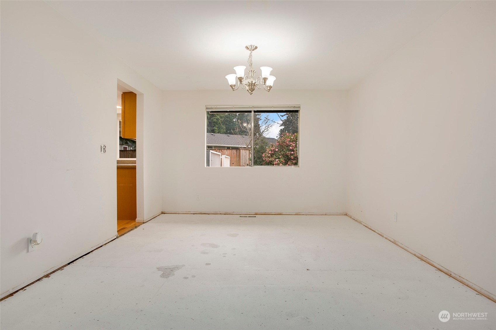 16810 143rd Avenue Southeast Renton, WA 98058 - Photo 7 of 38 an empty room with chandelier and windows