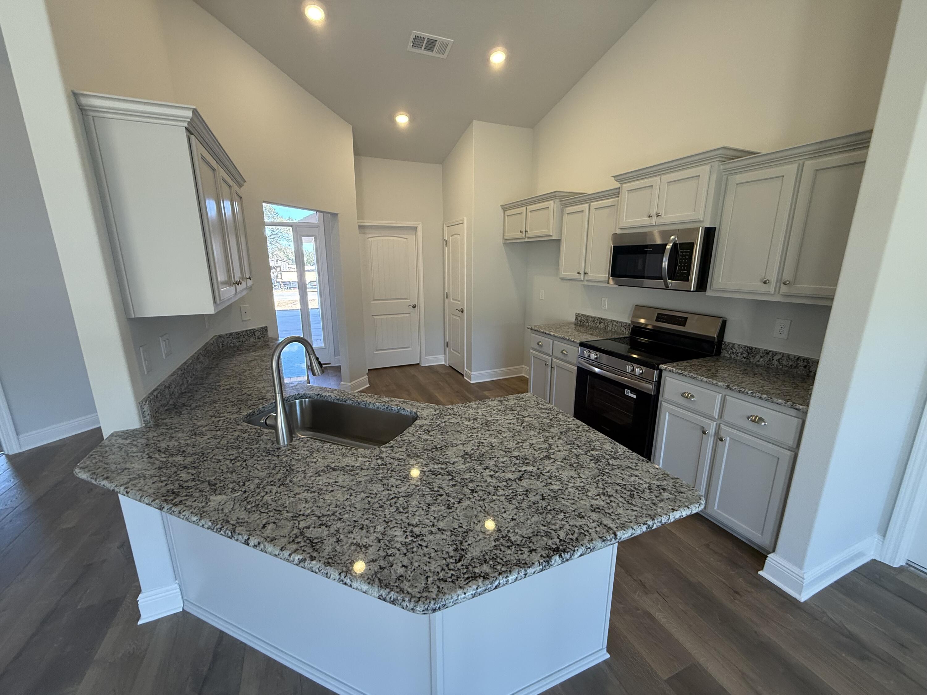 6011 Crocket Cove Crestview, FL 32539 - Photo 11 of 18 a kitchen with stainless steel appliances granite countertop a sink stove and refrigerator