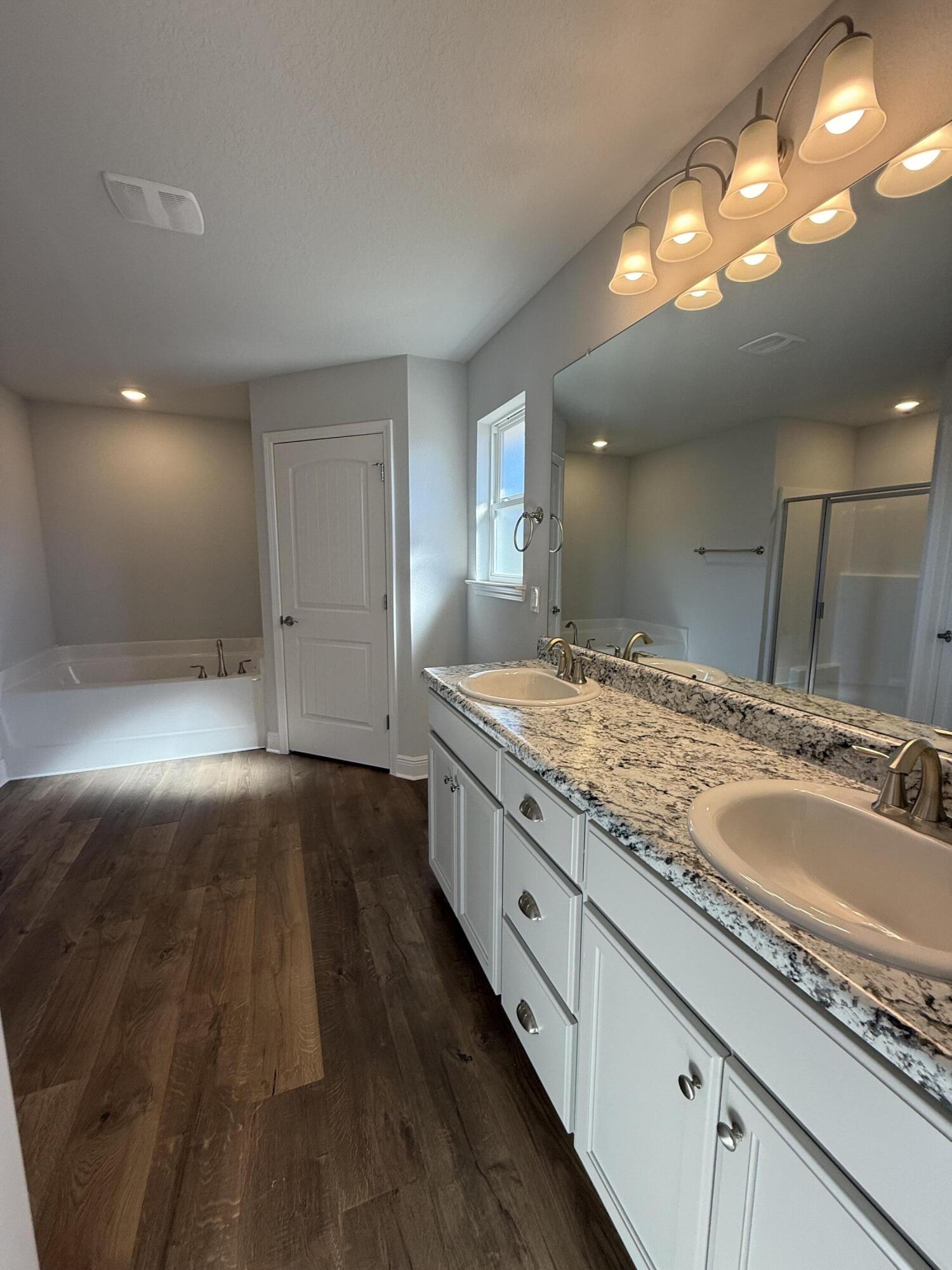 6011 Crocket Cove Crestview, FL 32539 - Photo 17 of 18 a bathroom with a granite countertop sink and a large mirror