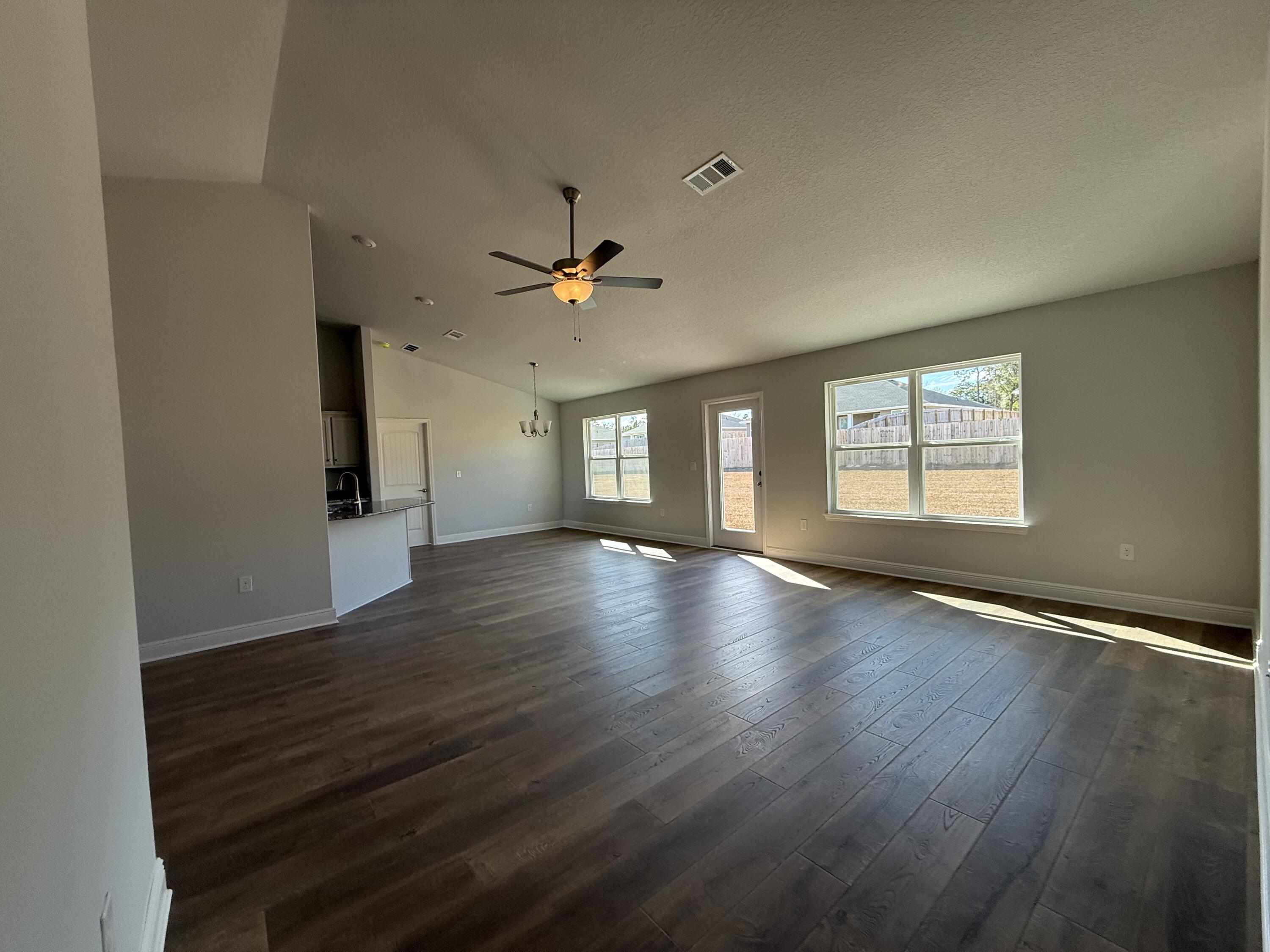 6011 Crocket Cove Crestview, FL 32539 - Photo 9 of 18 a view of an empty room with window and wooden floor