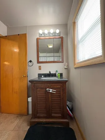 a bathroom with a sink a mirror and a window