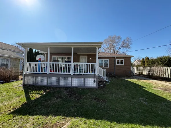 a view of a house with a yard and deck