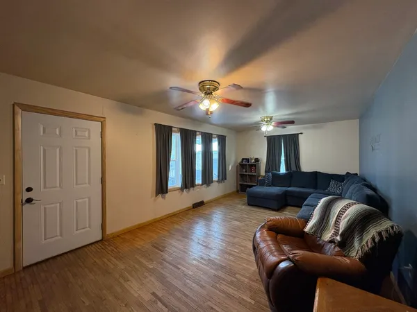 a living room with furniture and a ceiling fan