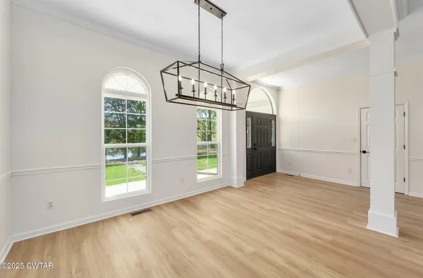 a kitchen with a table chairs and wooden floor