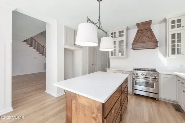 a spacious bedroom with a bed and a chandelier