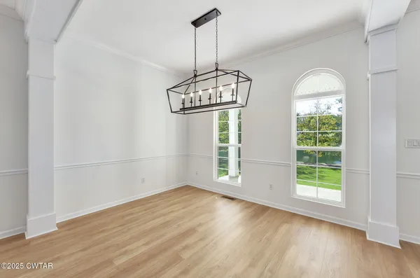 a view of empty room with fireplace and wooden floor
