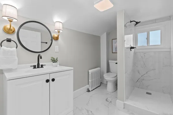 a bathroom with a toilet a sink and a mirror