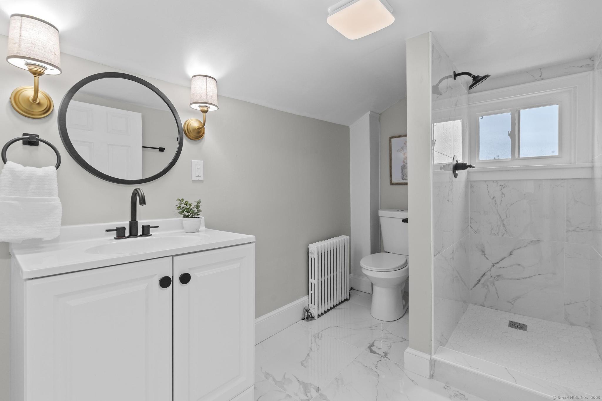 72 Spencer Street Suffield, CT 06078 - Photo 11 of 39 a bathroom with a toilet a sink and a mirror