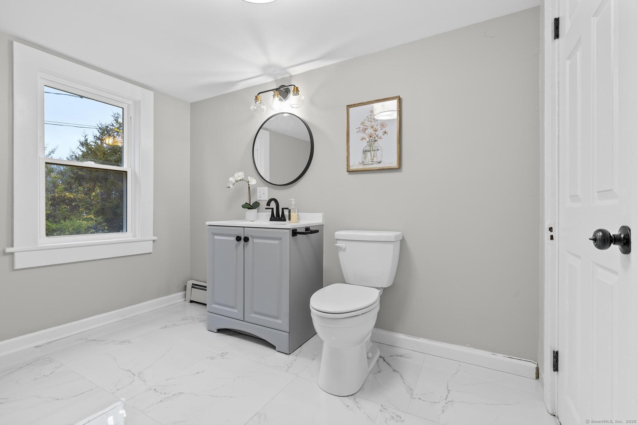72 Spencer Street Suffield, CT 06078 - Photo 12 of 39 a bathroom with a toilet sink a mirror and window