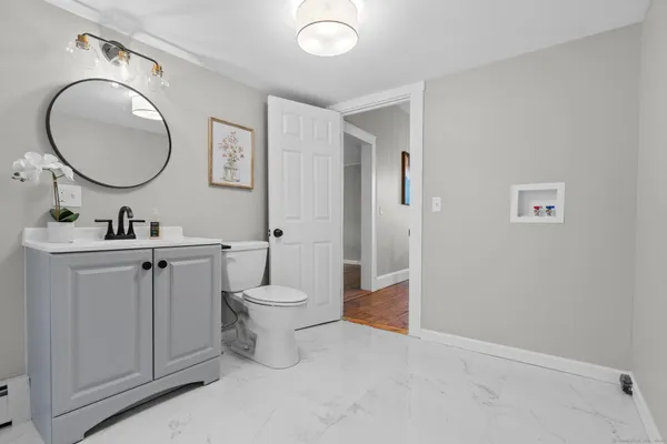 a bathroom with a toilet a sink and a mirror