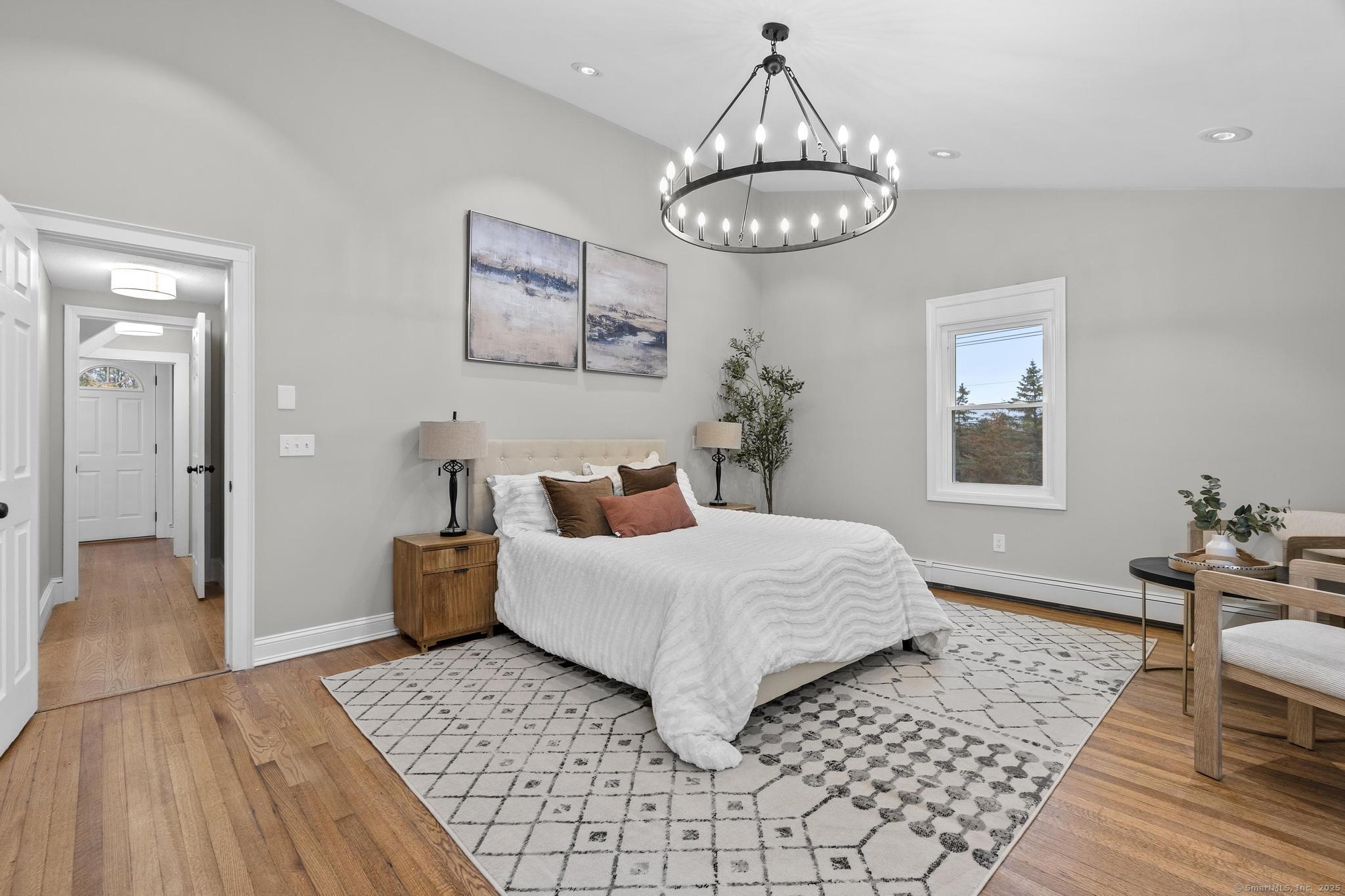 72 Spencer Street Suffield, CT 06078 - Photo 14 of 39 a bedroom with a bed and a chandelier