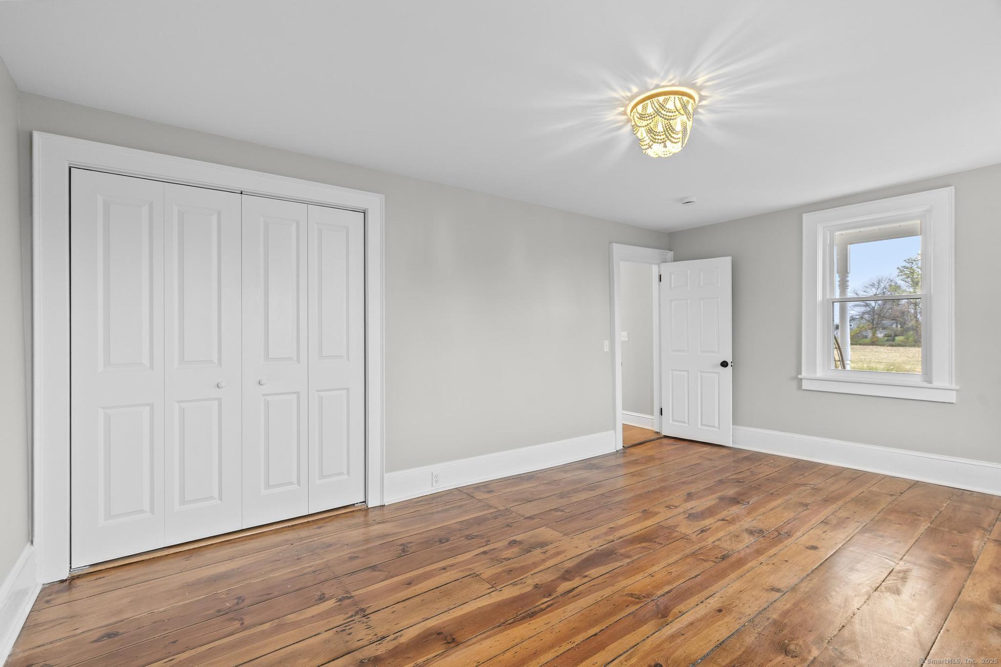72 Spencer Street Suffield, CT 06078 - Photo 20 of 39 a view of an empty room with window and wooden floor