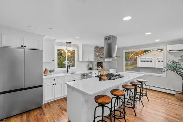 a kitchen with a sink a stove cabinets and wooden floor