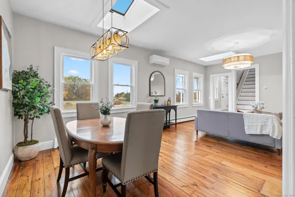 a dining room with furniture potted plants and wooden floor