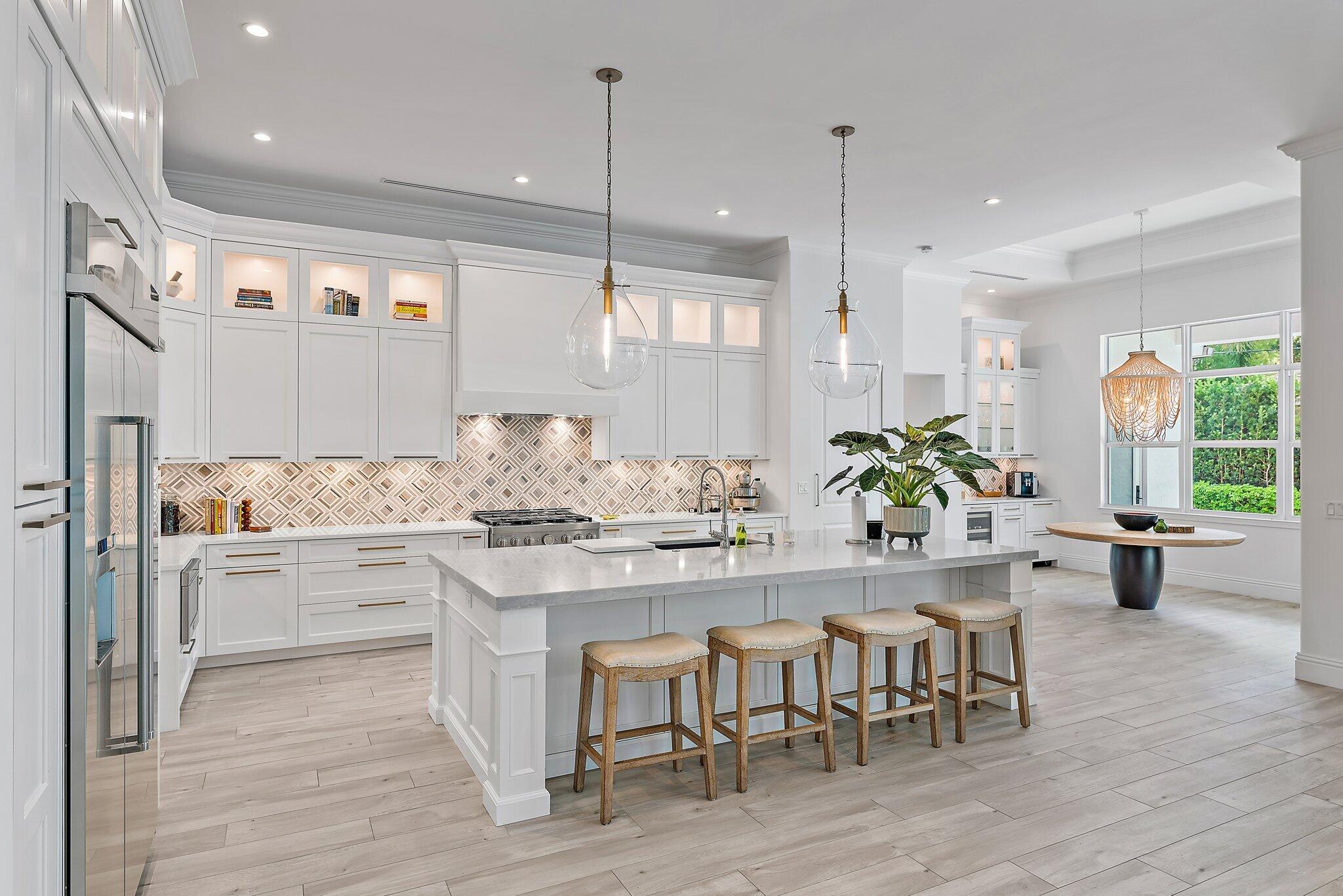 5456 Hibiscus Road Jupiter, FL 33458 - Photo 17 of 48 a room with stainless steel appliances kitchen island granite countertop a table chairs and a view of living room