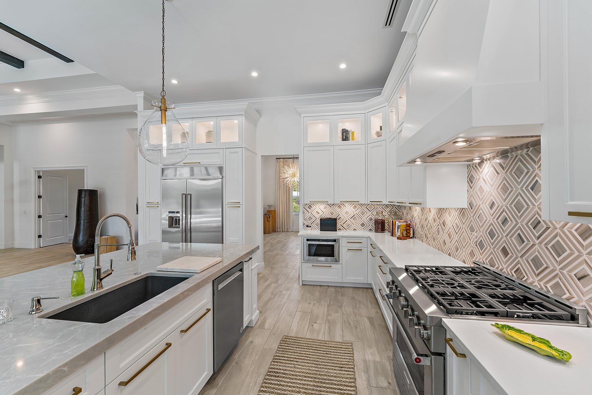 5456 Hibiscus Road Jupiter, FL 33458 - Photo 18 of 48 a kitchen with granite countertop a sink stove and cabinets