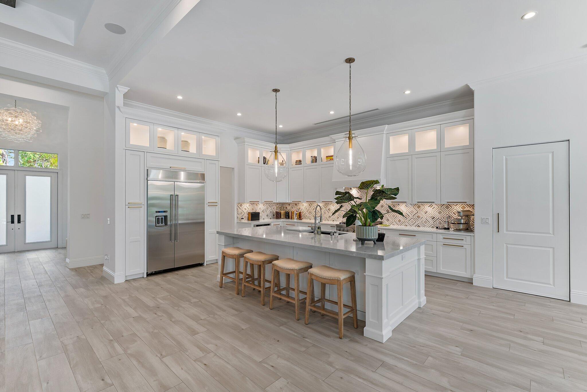 5456 Hibiscus Road Jupiter, FL 33458 - Photo 21 of 48 a kitchen with stainless steel appliances kitchen island granite countertop a stove refrigerator and a wooden floor