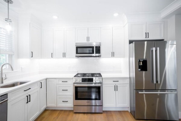 a kitchen with white cabinets and stainless steel appliances