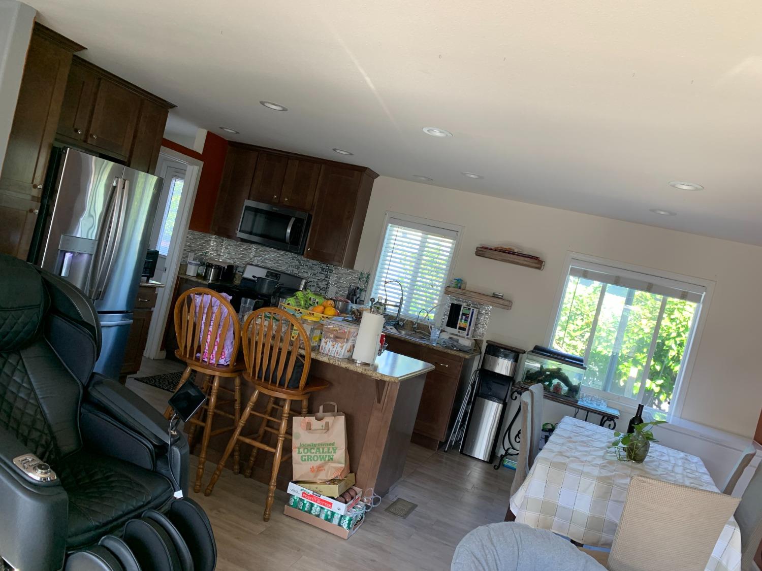 1624 South State Route 99 E Frontage Road, Unit 7 Manteca, CA 95336 - Photo 11 of 12 a living room with furniture a flat screen tv and a floor to ceiling window