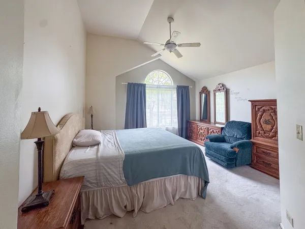 a bedroom with a large bed and a chandelier
