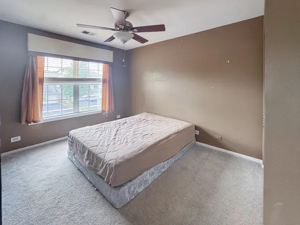 a bed sitting in a bedroom next to a window